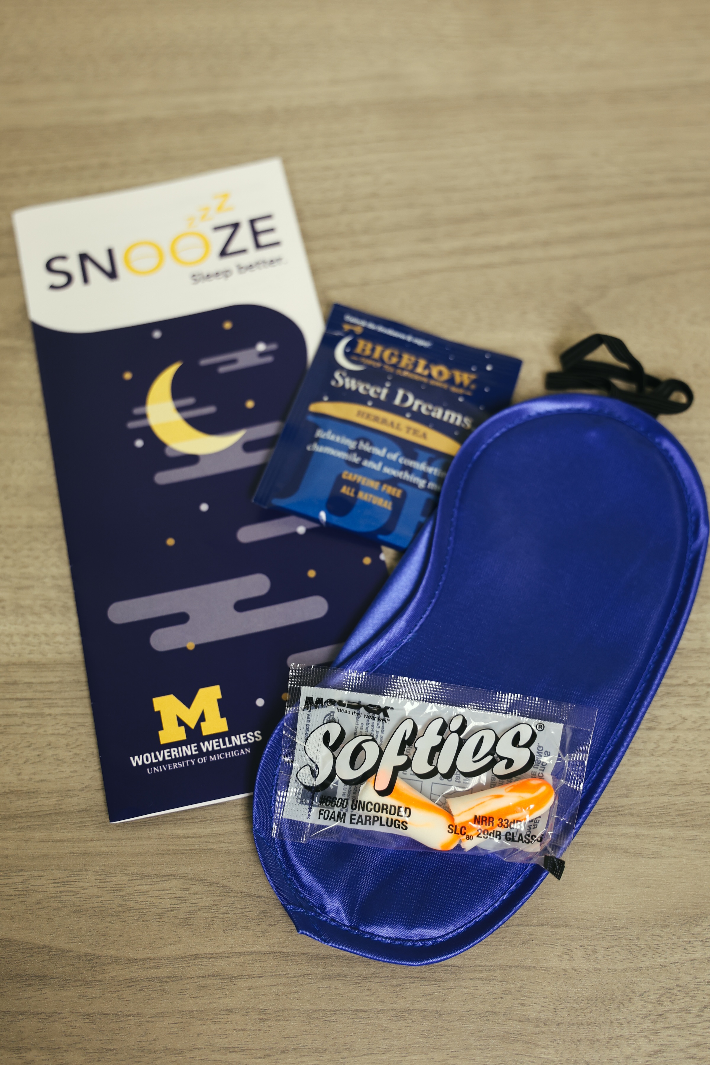   A Snooze sleep kit containing a pamphlet, tea, eye mask, and earbuds.