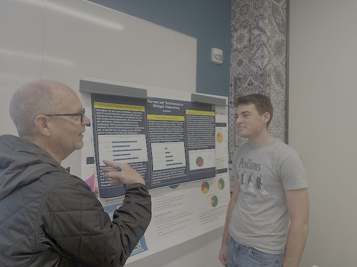 A student listening to the gallery guest about their thoughts regarding the poster. 