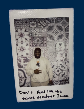 polaroid of man standing against wall mural